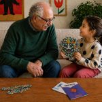 Child and grandfather playing with a LinkKit dinosaur large pouch textile kit